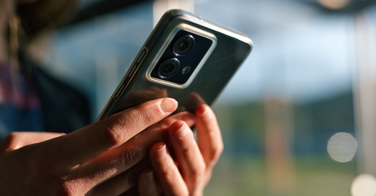 Persona sosteniendo un teléfono frente a su rostro durante una verificación en línea